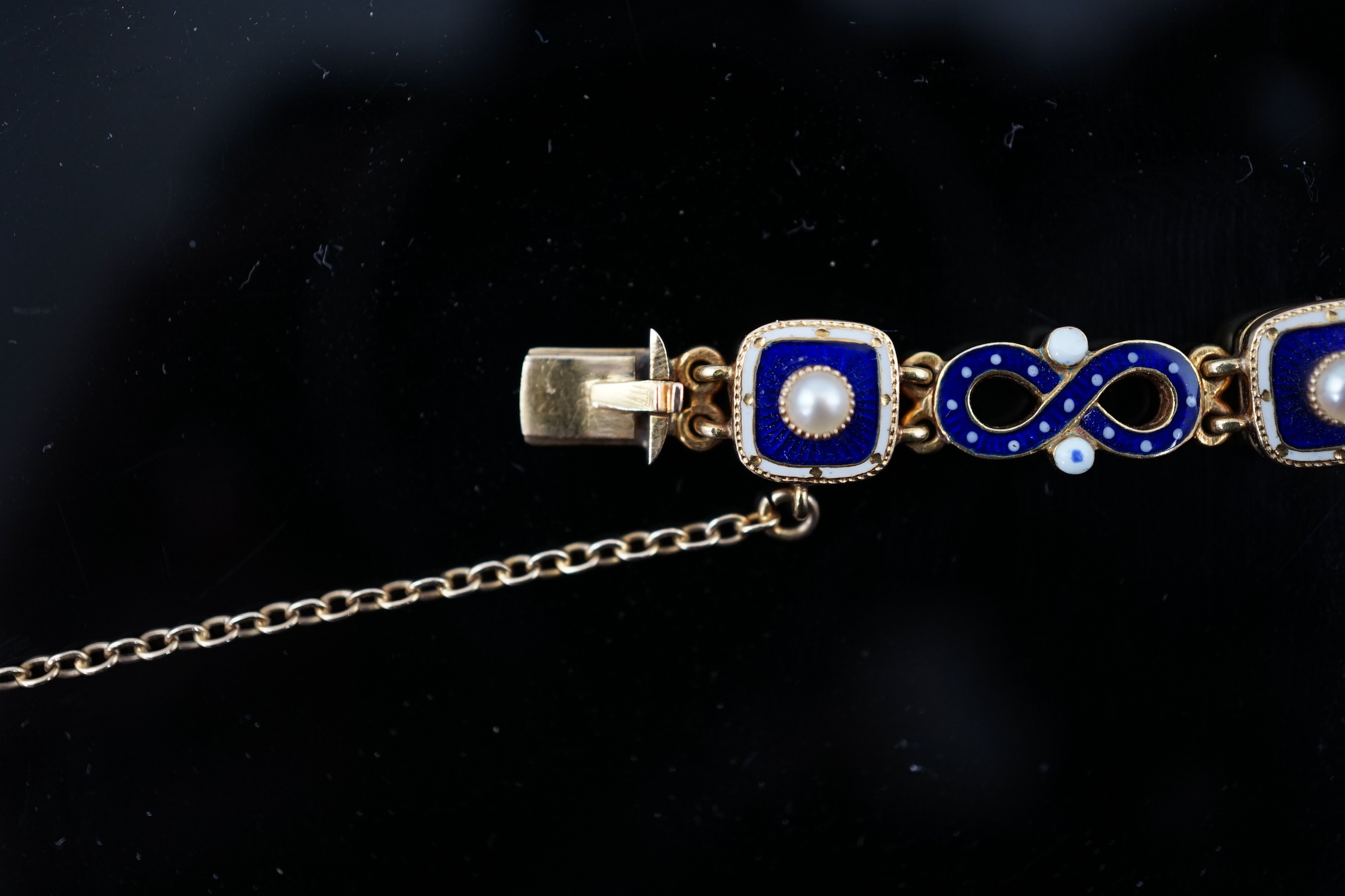 An early 20th century gold (tests as 18ct), two colour enamel and spilt pearl set bracelet